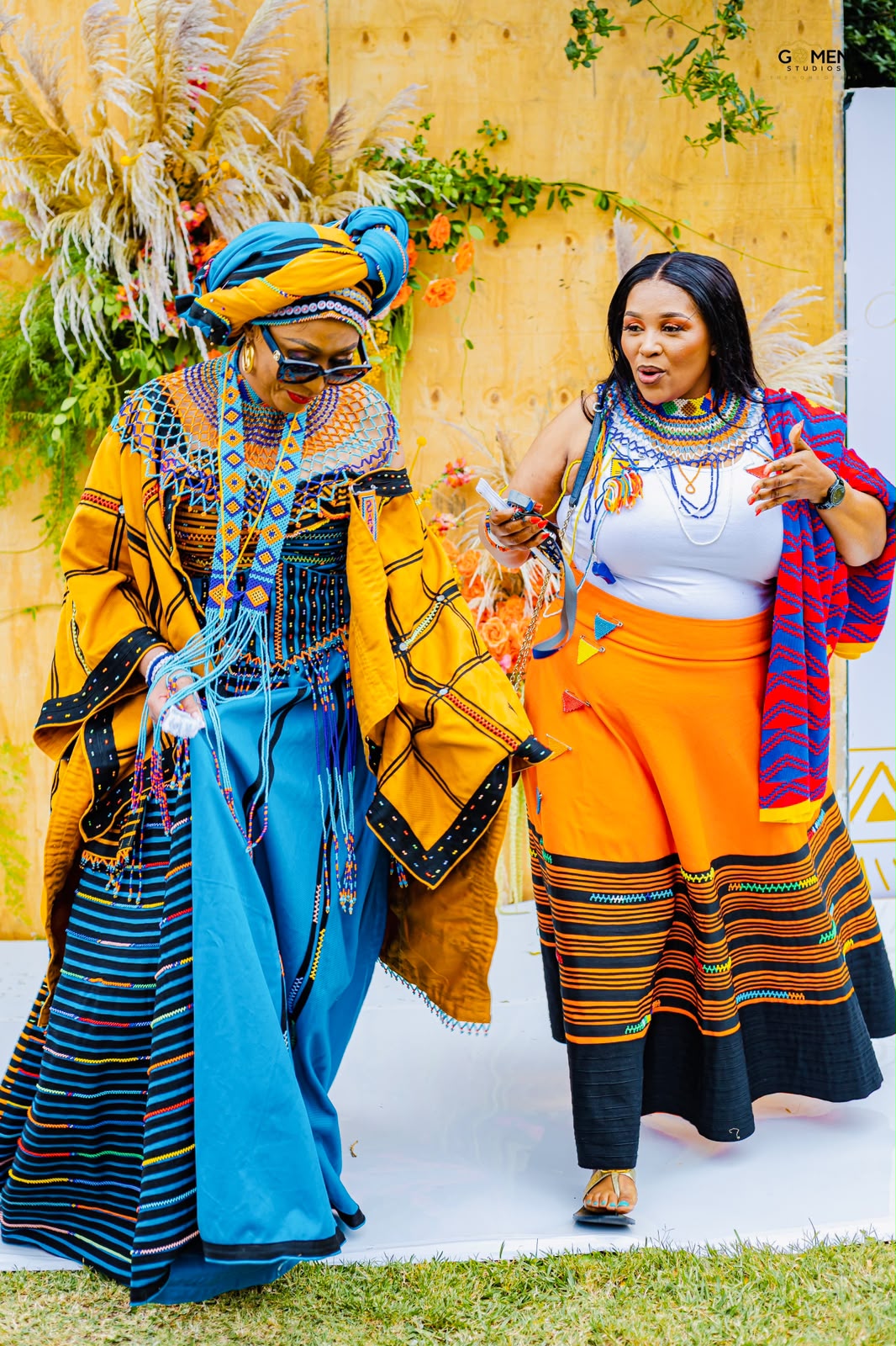 Two women walking in traditional Xhosa attire