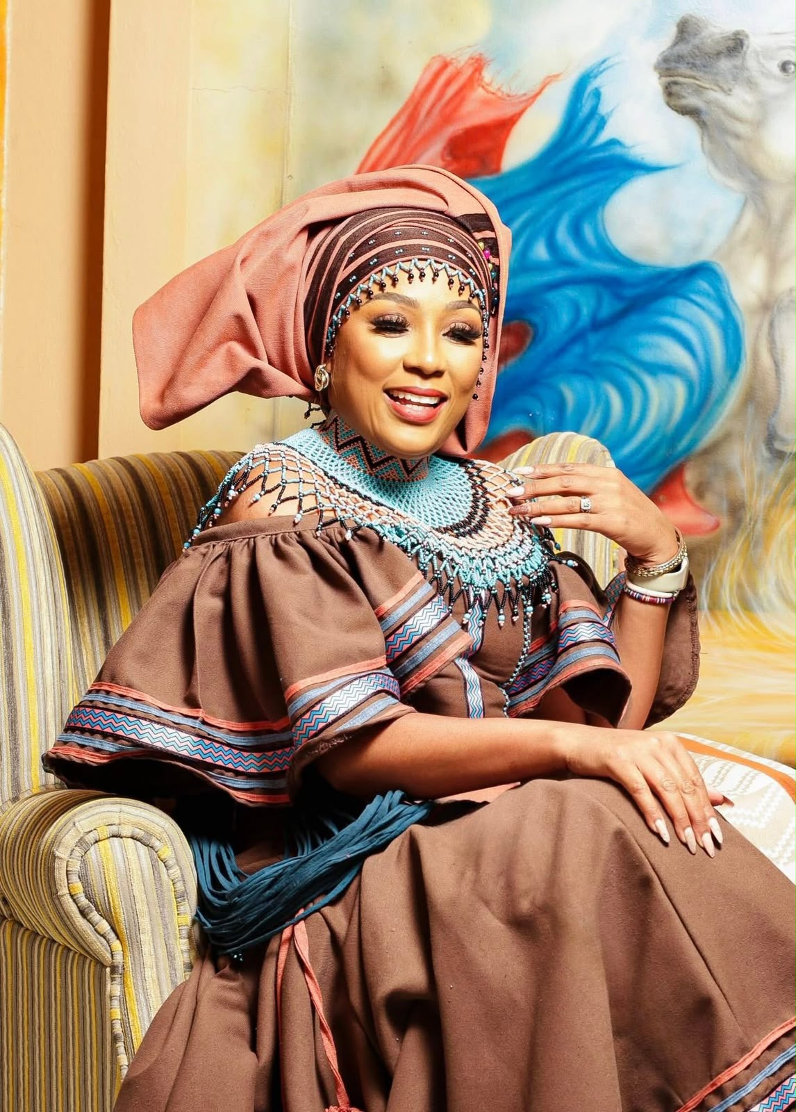 Buli smiling in brown Xhosa dress and beaded collar